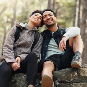a couple sitting on a rock
